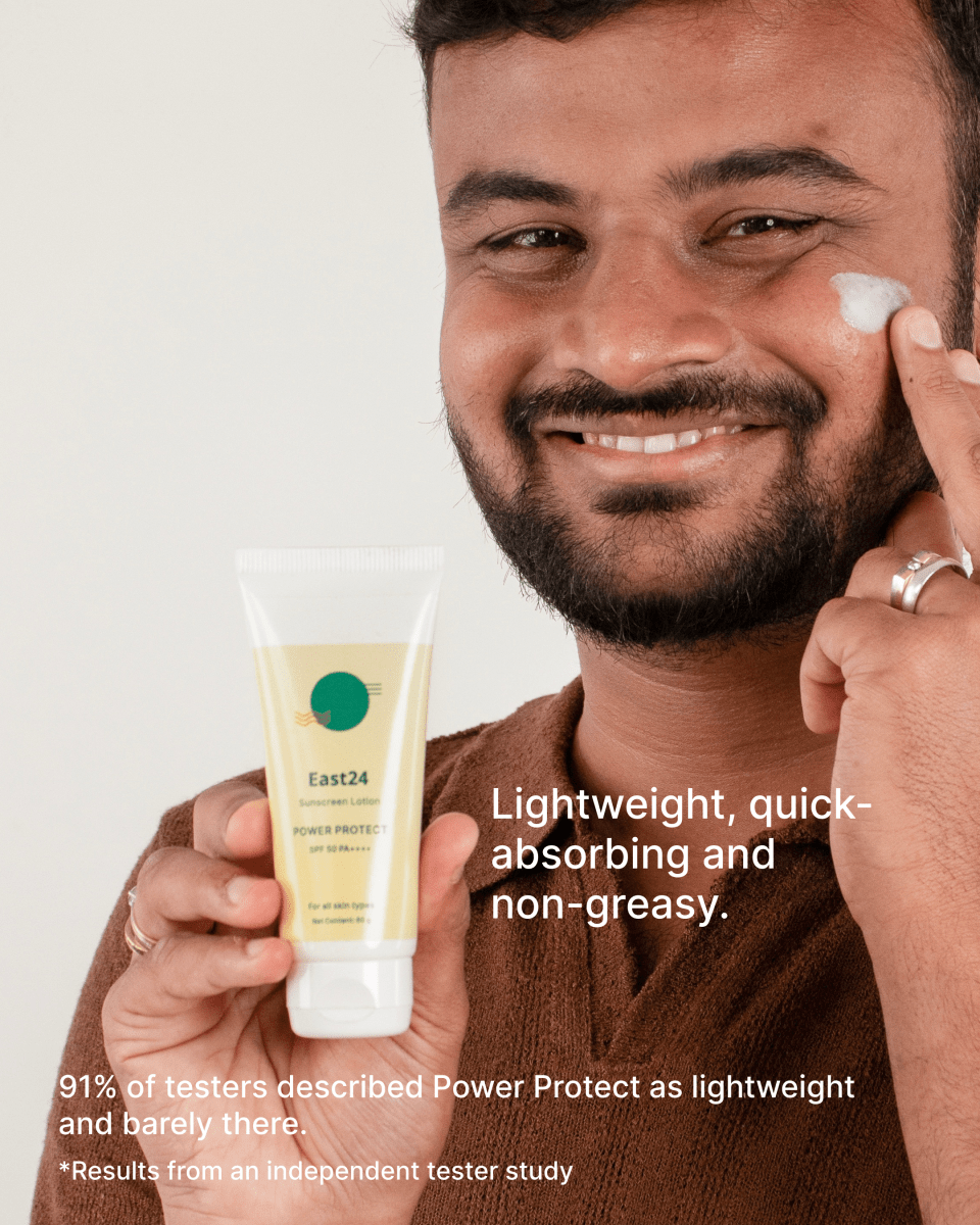 Man applying East24 SPF 50 PA++++ Power Protect sunscreen on a white background.